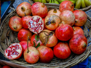 A basket full of juicy pomegranates on display in local market. Source of antioxidants.