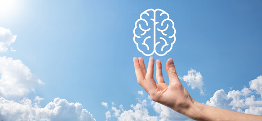 Male hand holding brain icon on blue background. Artificial intelligence Machine Learning Business Internet Technology Concept.Banner with copy space
