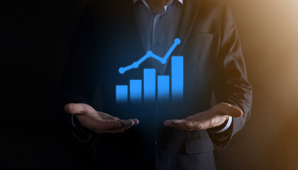 Businessman man holding a graph with positive profits growth. plan graph growth and increase of chart positive indicators in his business.more profitable and growing.