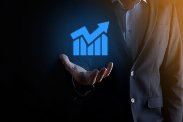 Fototapeta na wymiar Businessman man holding a graph with positive profits growth. plan graph growth and increase of chart positive indicators in his business.more profitable and growing.