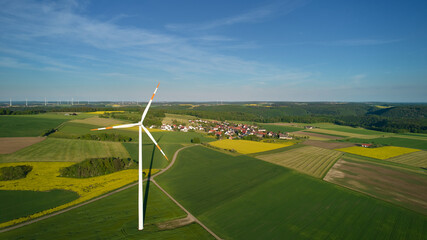 Obraz premium agriculture field with turbine near a village in germany. Swabian alb.
