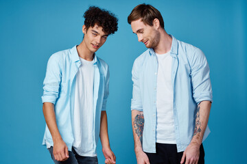 two men on a blue background gesturing with their hands team friendship communication