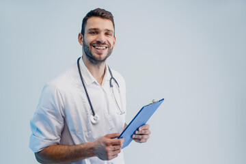 Smiling male doctor with stethoscope and clipboard