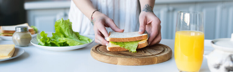 partial view of woman preparing breakfast near glass of orange juice, banner