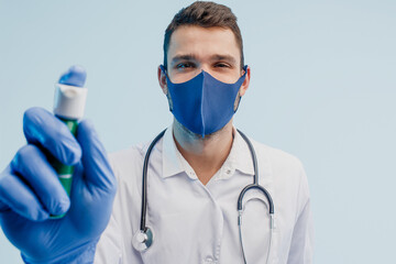 European male doctor showing inhaler in studio