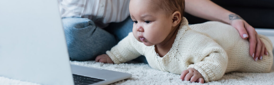 african american baby girl on floor near laptop and mother, banner