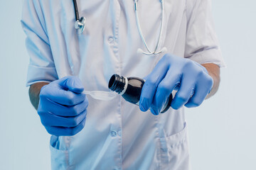 Male doctor pouring syrup from bottle to spoon