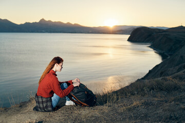 Fototapeta premium woman on vacation resting in the mountains near the sea at sunset