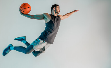 Sportsman jumping and want throw basketball ball