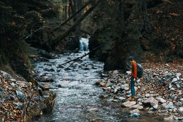 traveler with backpack landscape mountains transparent river pond and forest in the background