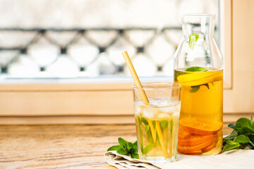 The glass of citrus iced tea on a marble tray and wooden table.