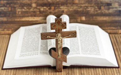 Wooden cross on the background of the Bible. Prayer.