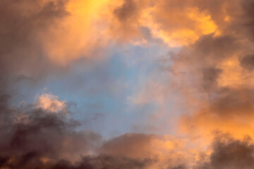 Cloudy landscape. Golden clouds illuminated by sunlight at sunset.