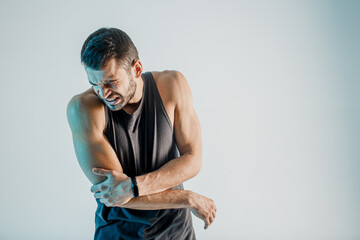 Exhausted young sportsman feeling pain in elbow - obrazy, fototapety, plakaty