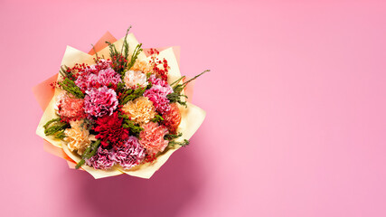 Colorful red and yellow carnation flowers bouquet on pink background