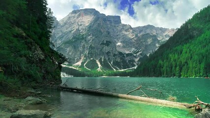 Flying above clear turquoise water on a famous alpine lake Lago di Braies ,Dolomites,Italy. Mountain ranges. fresh dense forest natural Landscape. - Powered by Adobe