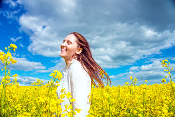 Pretty young woman in the rapeseed field