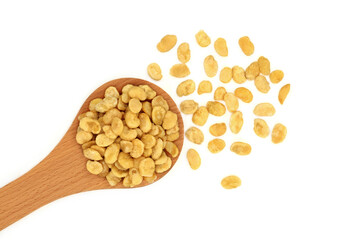 Roasted fava beans for a healthy vegan diet snack food in a wooden spoon and loose on white...