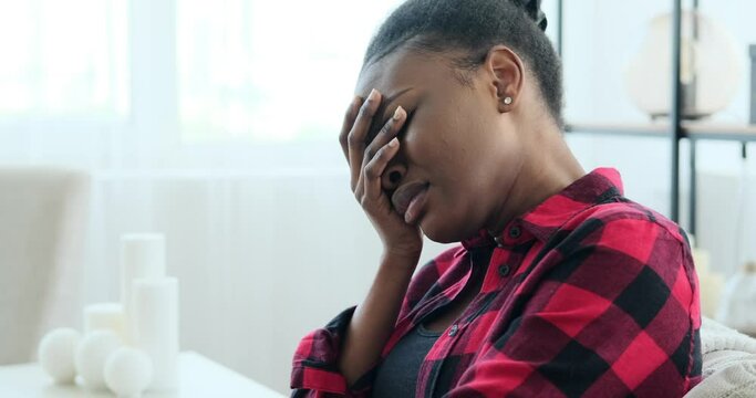 Desperate woman crying on sofa at home