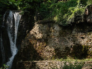 naturalny wodospad na skale wśród zieleni - poziomo - obrazy, fototapety, plakaty
