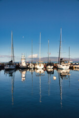 View of the lahaina harbor at dawn with setting moon and lanai in the distance