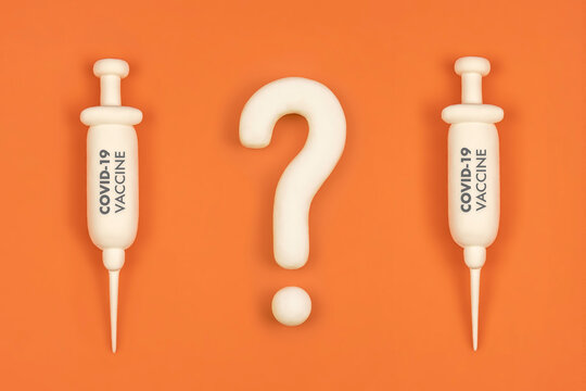 Vaccine hesitancy concept, syringes with vaccine and question mark. Doubts and hesitations about covid-19 vaccine, risks and side effects discussion.