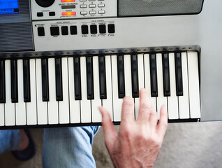 Close-up of a music performer's man hand playing a synthesizer