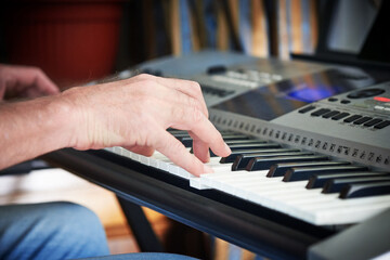 Obraz premium Close-up of a music performer's man hands playing the electric piano
