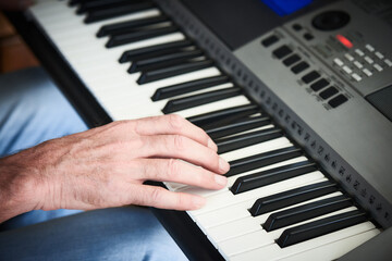 Fototapeta na wymiar Close-up of a male hand playing the electric piano