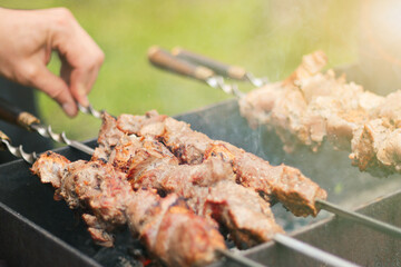 meat on skewers roasted over the coals.picnic in nature. preparation of a shish kebab.