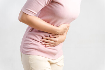 Young woman suffering from strong abdominal pain on white background. Gastritis, Period, menstruation..
