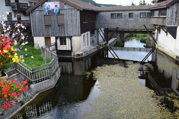 Fototapeta na wymiar Ancienne usine scierie travail du bois Jura rivière architecture traditionnelle bâtiments anciens village tourisme