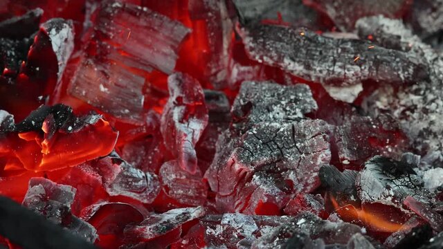 Stirring aglow coals with metal poker rake