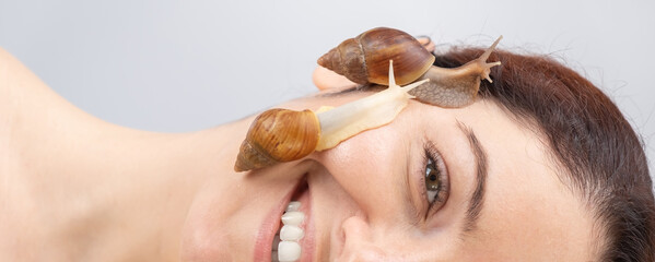 A beautiful caucasian woman is lying on her side and snails are crawling over her face. Skin care and anti-aging © Михаил Решетников