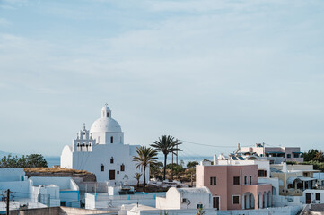 Cityscape of traditional village Karterados on Santorini island, Greece. Traditional white architecture. View of the Greek Orthodox church with bell tower.