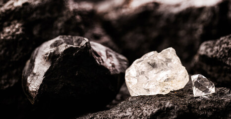 rough diamond next to a cut diamond, in a coal mine, concept of mining and mineral extraction