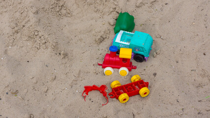 Fototapeta na wymiar Children's plastic toys forgotten in the sandbox.