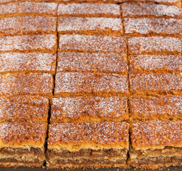 brown cake pieces aligned on black plate. White sugar ornament