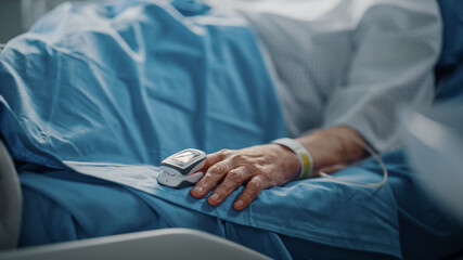 Hospital Ward: Senior Woman Resting in a bed with Finger Heart Rate Monitor / Pulse oximeter...