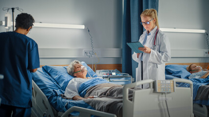Hospital Ward: Female Head Nurse and Professional Doctor Making Rounds Checkup on Sleeping Elderly Woman Patient Resting in Bed. They Talk, Check Computer for Vitals while Old Lady Fully Recovering