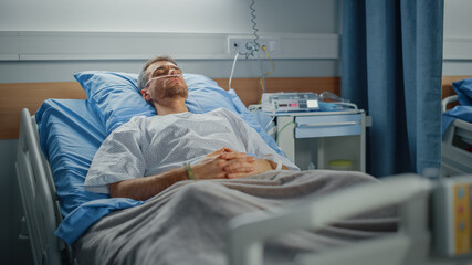 Hospital Ward: Portrait of Handsome Young Man Wearing Nasal Cannula Sleeping in Bed, Fully...