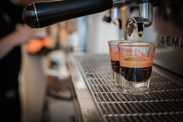 closeup black coffee in measuring cup put on coffee maker,coffee machine making espresso