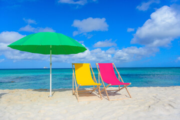 Beach chairs with umbrella on the shoreline, beautiful beach