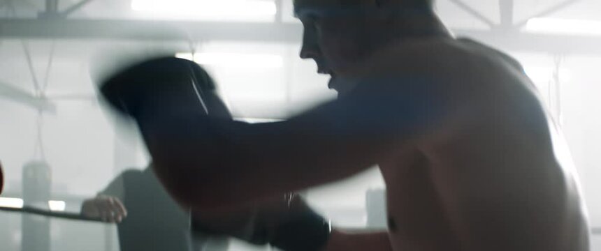 HANDHELD Two fighters having a kickboxing sparring fight, trainers watching. Dynamic cinematic footage. Shot with 2x anamorphic lens