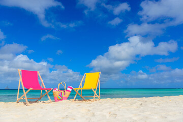 Beach chairs, beach bag, flip flops, beach towel on the shoreline, beautiful beach