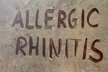 Allergic rhinitis text over yellow pollen grains on the background.