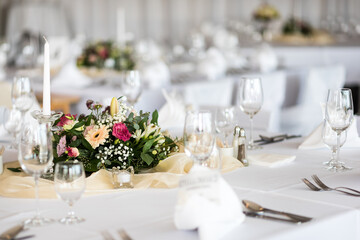 Detail of flowers on a wedding table which is ready for the guests and bride with the groom.