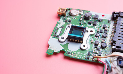 Electronic circuit board on pink background