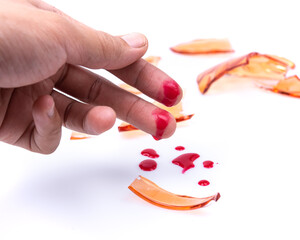 Broken glass cut a middle finger got some blood on white background.