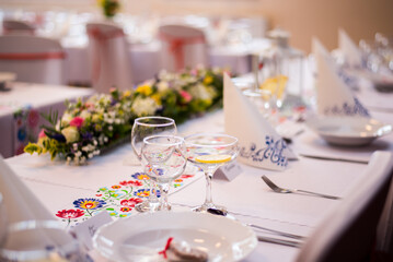 Detail of flowers on a wedding table which is ready for the guests and bride with the groom.